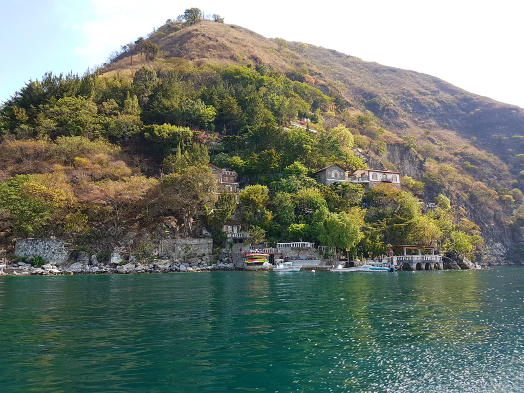 Rund um den See liegen die Häuser malerisch in den umgebenen Berghängen